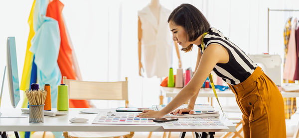 Side view of fashion designer working at studio