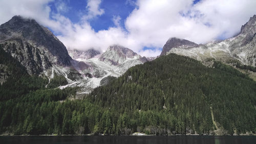 Scenic view of lake and mountains against cloudy sky