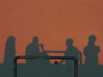 Shadow of people on white wall during sunset