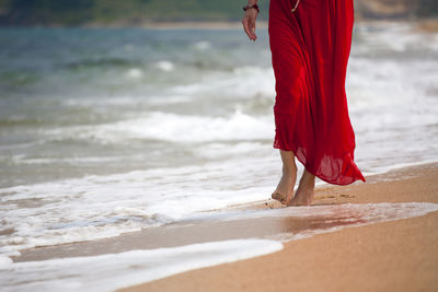 Low section of woman standing on beach