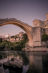 Arch bridge over river against sky