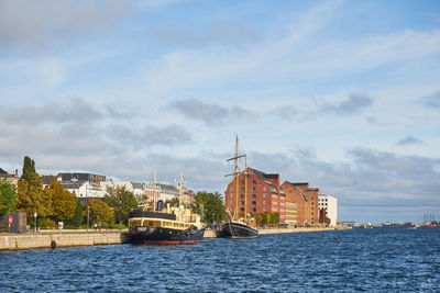 Buildings by sea against sky in city