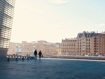 People walking on street against buildings in city