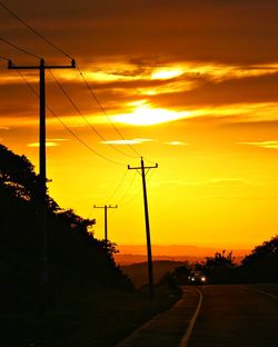 Silhouette road against sky during sunset
