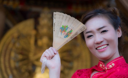 Close-up of smiling young woman holding umbrella