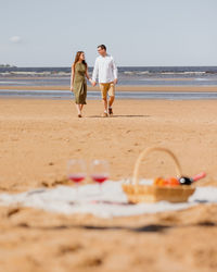 Couple of a man and a woman on a date on the beach by the sea.  walk picnic of two lovers in nature