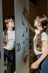 Side view of mother and daughter sitting at home