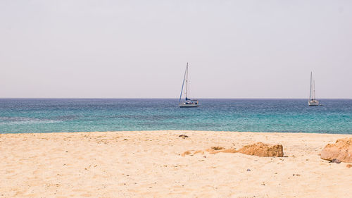 Sailboat on beach against sky