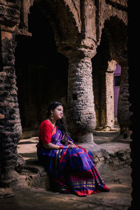 Woman sitting outside building