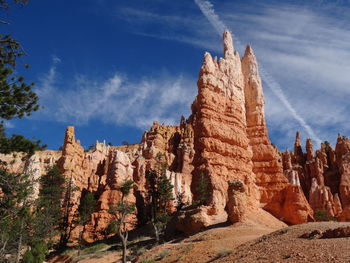 Low angle view of rock formation against cloudy sky