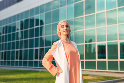 Portrait of woman standing against building