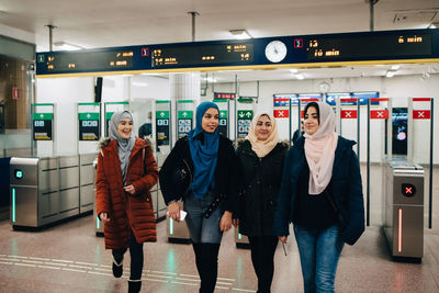 Happy multi-ethnic muslim friends walking at subway station