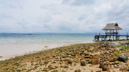 Lifeguard hut on beach against sky