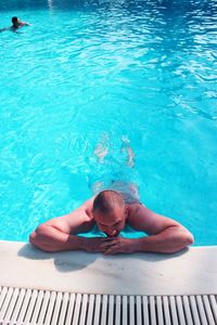 High angle view of shirtless man swimming in pool