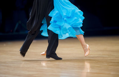 Low section of couple dancing on floor