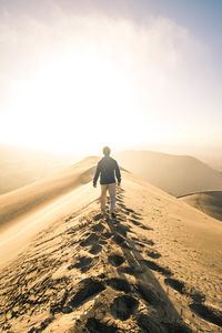 Rear view of man on land against sky