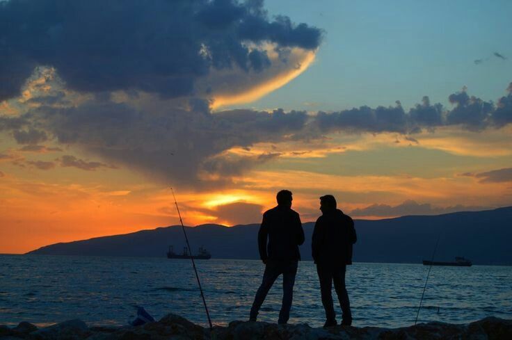 sky, sunset, horizon, water, sea, silhouette, cloud, ocean, beauty in nature, men, two people, nature, dusk, beach, evening, scenics - nature, land, afterglow, adult, togetherness, coast, mountain, standing, vacation, shore, travel, trip, full length, leisure activity, orange color, holiday, tranquility, sun, outdoors, tranquil scene, travel destinations, idyllic, sunlight, rear view, lifestyles, environment, friendship, activity, emotion, positive emotion