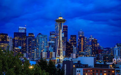 Illuminated cityscape against sky at night