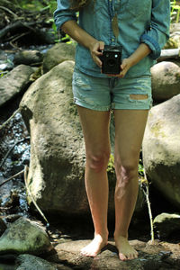 Woman photographing on rock