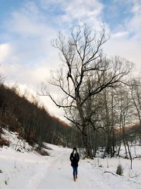 Full length of person on snow covered field against sky