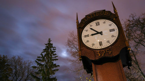 Low angle view of clock tower against sky at night
