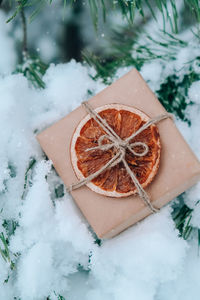 Christmas eco gift in rustic vintage style with dried orange slice. winter holidays mock up on snowy