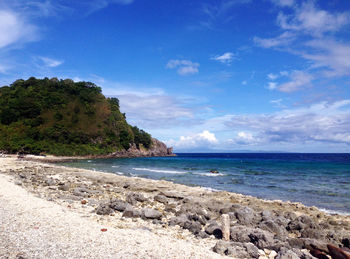 Scenic view of beach against blue sky