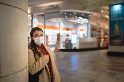 Portrait of young woman standing at home