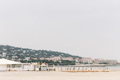 Beach in town against clear sky