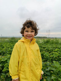 Cute boy smiles at strawberry field