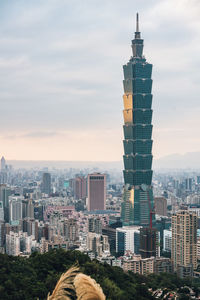 Modern buildings in city against cloudy sky