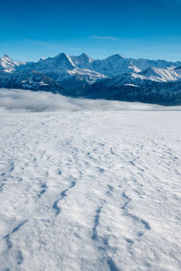 Scenic view of snowcapped mountains against blue sky