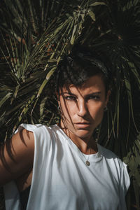 Portrait of young man standing against plants