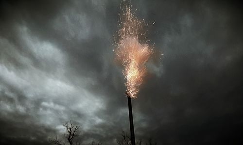 Low angle view of street light against cloudy sky