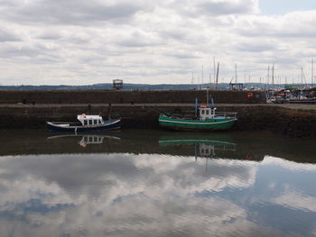 Boats moored in sea against sky