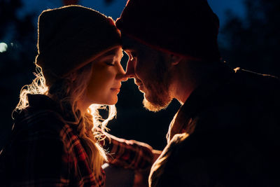 Young couple kissing outdoors at night