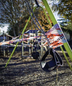 Close-up of swing hanging on field during the lockdown