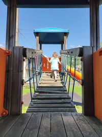 Rear view of man standing against blue sky