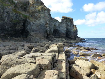 Scenic view of rocks on beach against sky