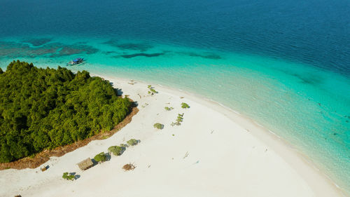 Sandy beach on a tropical island with palm trees by coral reef atoll. patawan island 