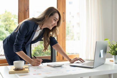 Side view of woman working at table