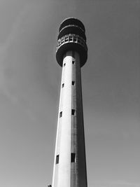 Low angle view of lighthouse by building against sky