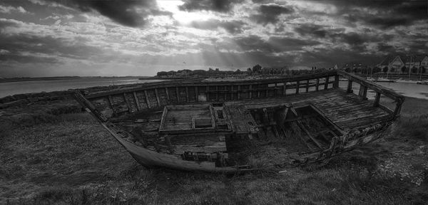 Abandoned boat on sea against sky