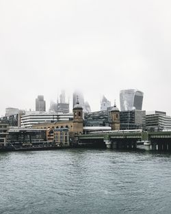 River by buildings against clear sky