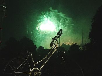Silhouette of bicycles against bright sky at night
