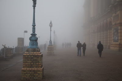 People walking in city against sky