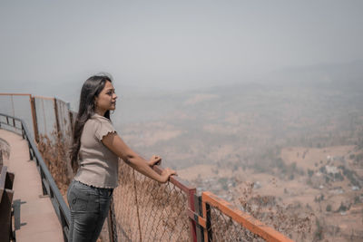 Portrait of young woman standing on mountain