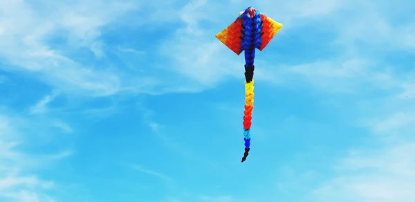 Low angle view of kite flying against blue sky