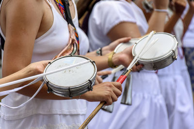 Women playing tambourine in the streets of brazil during a samba performance at carnival in brazil