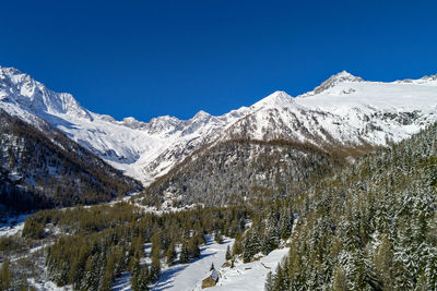 Scenic view of snowcapped mountains against clear blue sky